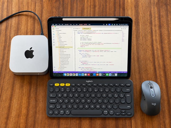 A Mac mini with no monitor attached, using an iPad as its only screen, with a keyboard and mouse on a wooden desk